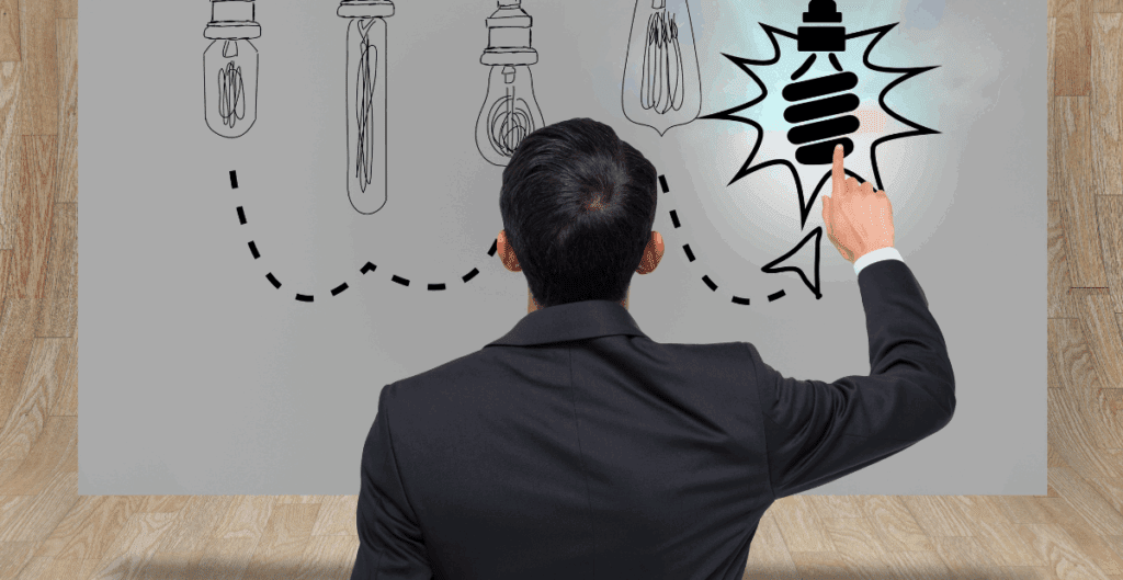 A businessman pointing at a stylized lightbulb sketch on a wall, symbolizing a new idea among a series of evolving lightbulb designs.