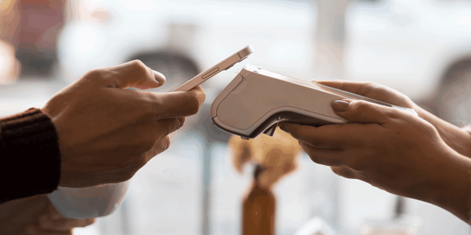 Customer making a contactless payment using a smartphone at a restaurant counter with a handheld POS device.